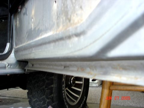 1979 Ford Bronco - Detail shot of the lower door sill and a tire on a vehicle.