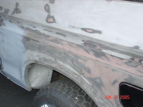 1979 Ford Bronco - A vehicle body panel is shown with primer and filler, indicating repair work is in progress.