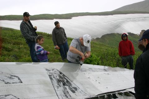 2003 Jeep TJ - Group examines and works on damaged aircraft fuselage in a scenic, overcast environment.