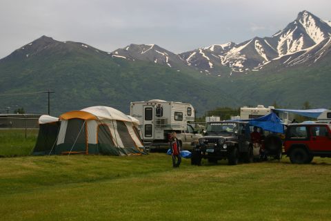 2003 Jeep TJ - Campground scene with multiple Jeeps and RVs under a cloudy sky with mountains.