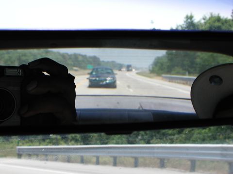 1992 Ford Taurus - Looking through the rear window at highway traffic while holding a camera.