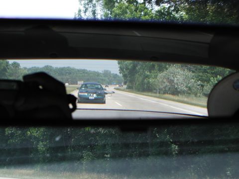 1992 Ford Taurus - View from the driver's seat looking out the rear window at traffic on the highway.