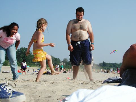 1992 Ford Taurus - A group of people enjoy a sunny day at the beach, with a kite visible in the sky.