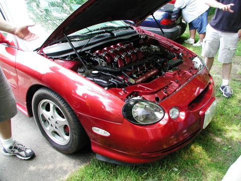 1992 Ford Taurus - The engine bay of a red 1992 Ford Taurus shows a custom red intake manifold with Yamaha branding.