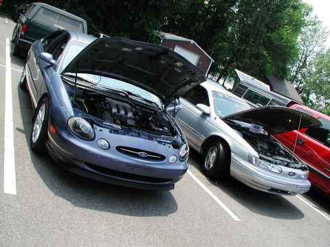 1992 Ford Taurus - A blue 1996 Ford Taurus is parked with its hood open, revealing the engine compartment.