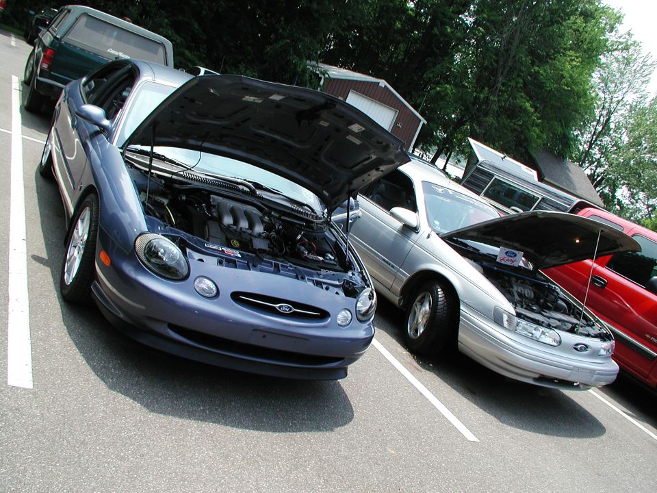 Blue 1996 Ford Taurus with hood open, showing engine