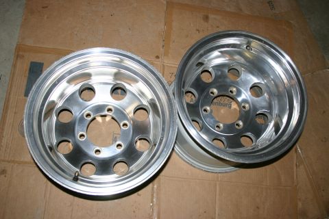 2003 Jeep TJ - A pair of shiny aluminum alloy wheels are displayed on a cardboard surface.