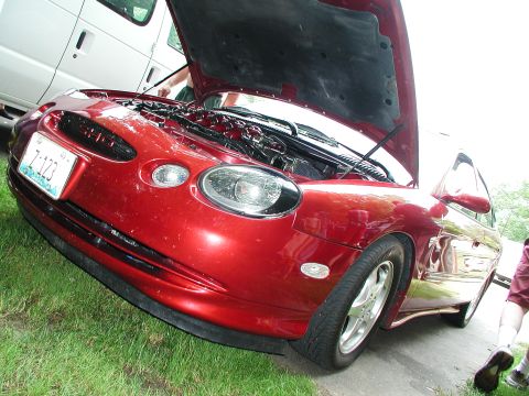 1992 Ford Taurus - A red sedan, likely a 1995 model, is parked on grass with its hood open, revealing the engine compartment.
