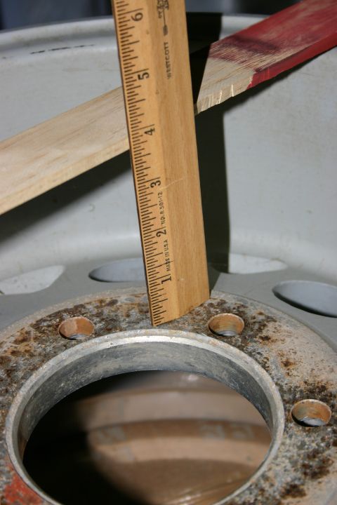 2003 Jeep TJ - A wooden ruler is used to measure the bolt circle diameter of a rusty wheel hub. The registry claims this is a 2003 Jeep TJ, but the image…