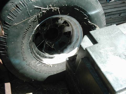 1978 Ford Bronco - Close-up of a BFGoodrich Mud-Terrain tire and wheel, with debris on the tire.