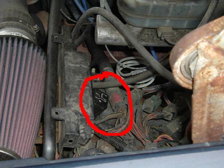 1991 Ford Bronco - This image shows a section of an engine compartment with various wires and a red-circled electrical connector.