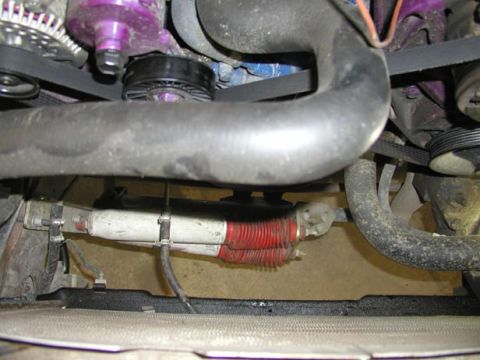 1988 Ford Bronco - Front of the engine with the fan and shroud pulled, showing the radiator core at the bottom of the frame and a white-painted steering linka…