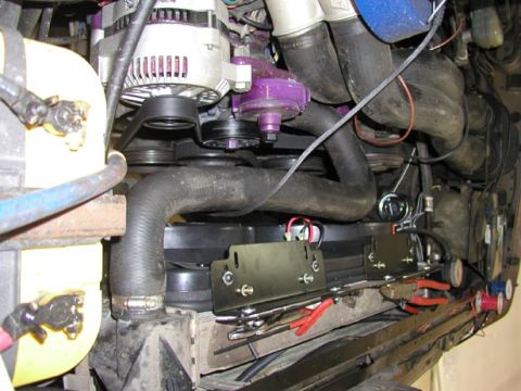 1988 Ford Bronco - Electric cooling fans mounted in front of the engine, their black shrouds held by bolted steel brackets across the radiator support with re…