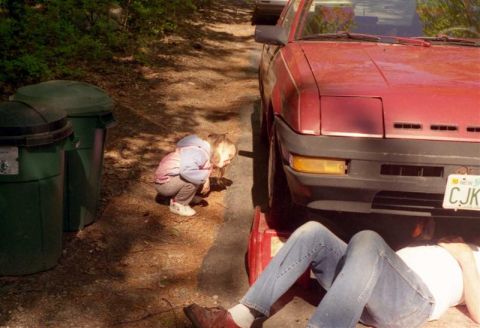 1991 Ford Bronco - Child observes mechanic working on a red car, possibly a Nissan 240SX.