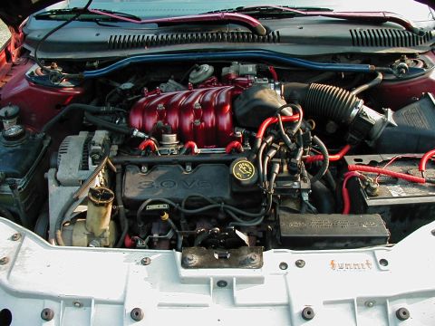 1997 Ford Taurus - Close-up of a 1997 Ford Taurus engine bay, showing the 3.0 V6 engine and aftermarket modifications.