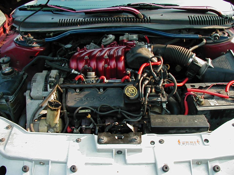 Engine bay with 3.0 V6 engine, red intake manifold, and red spark plug wires. Summit Racing sticker visible