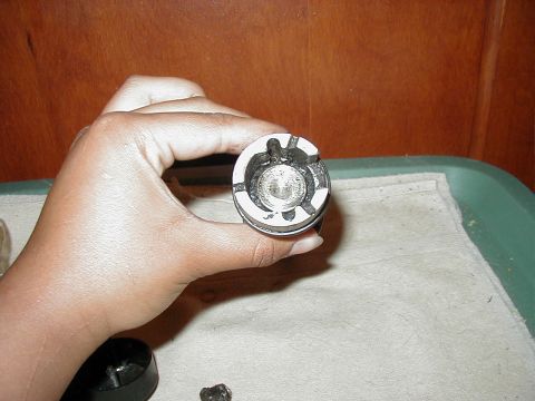 1997 Ford Taurus - A hand holds a car part with visible internal splines against a wooden background.
