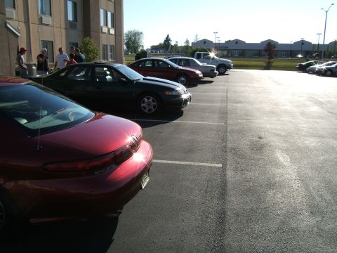 1998 Ford Taurus - A red 1998 Ford Taurus is parked in a lot with other vehicles.