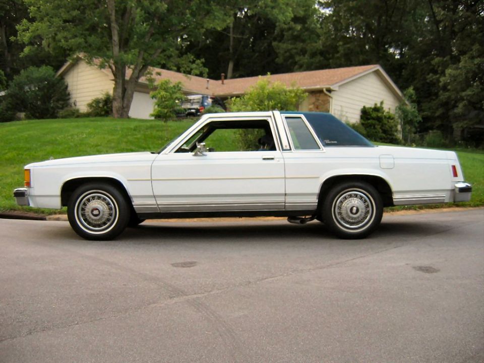 White Ford LTD Crown Victoria two-door coupe side profile on residential street