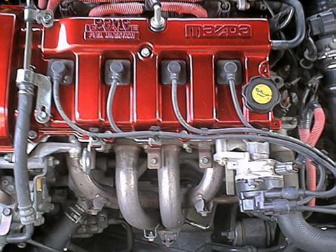 1994 Ford Probe - Close-up of a red Mazda engine valve cover, showing "16 VALVE DOHC" and "Mazda" branding.