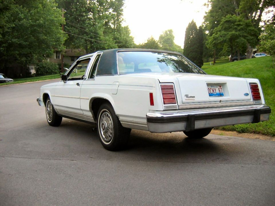 White Ford LTD Crown Victoria coupe rear three-quarter view with Ford badge