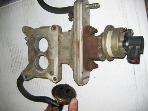 1985 Ford Crown Victoria LTD - This is a close-up of a vehicle's exhaust gas recirculation (EGR) valve and throttle body assembly.