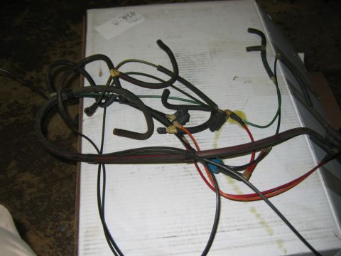 1985 Ford Crown Victoria LTD - A tangled engine wiring harness lies on a white surface, likely a part for a vehicle.