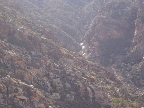 1996 Ford Bronco - Rocky mountainside with a dry creek bed visible.