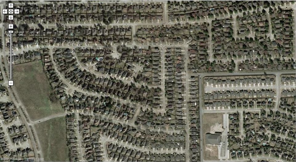 Aerial view of a suburban neighborhood with many houses and streets. A Supermotors logo is in the bottom right corner