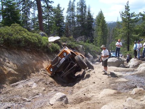 1998 Ford Ranger - An off-road vehicle is stuck on a steep, rocky incline while onlookers observe the situation.