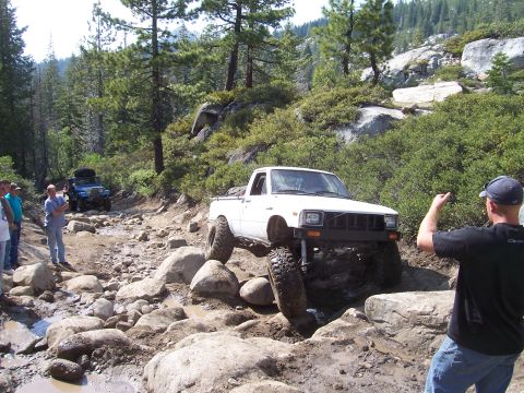 1998 Ford Ranger - Off-road enthusiasts tackle a challenging rocky path with their modified trucks.