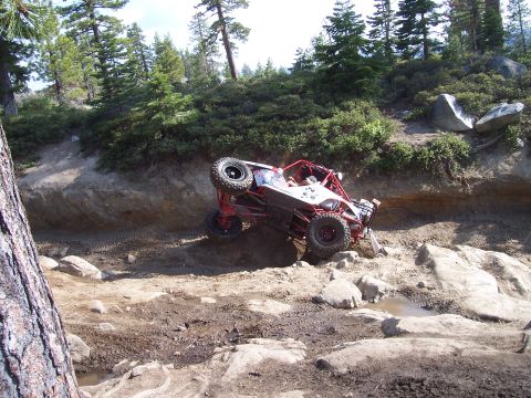 1998 Ford Ranger - Off-road buggy navigates a challenging rocky trail in a wooded area. Supermotors.net logo visible.