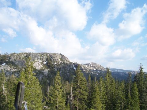 1998 Ford Ranger - A scenic view of mountains and pine trees under a cloudy blue sky.