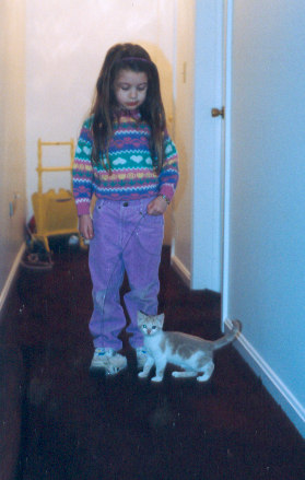 1991 Ford Bronco - A young girl stands in a hallway next to a kitten, with a website URL visible at the bottom of the image.