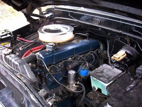 1968 Ford F-100 - The engine bay of a 1968 Ford F-100 shows a blue V8 engine with a chrome air filter housing.