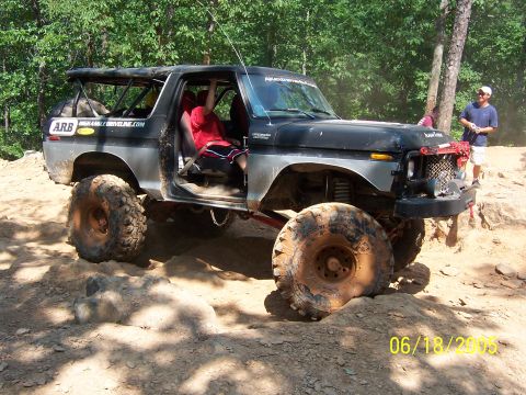 1978 Ford Bronco - A modified 1978 Ford Bronco navigates a challenging off-road course on a sunny day.