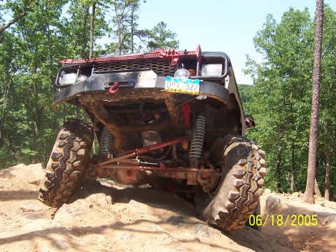 1978 Ford Bronco - An off-road vehicle navigates a challenging rocky path on a sunny day.