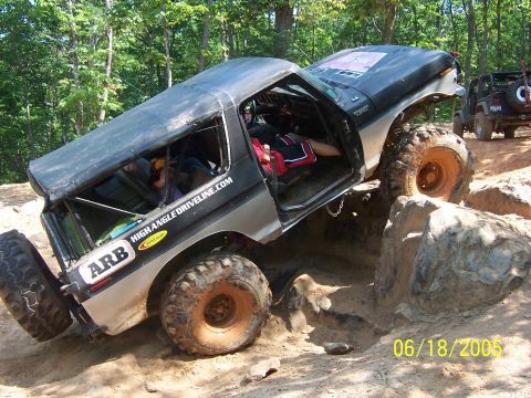 1978 Ford Bronco - This 1978 Ford Bronco navigates a challenging rocky trail, its off-road capabilities with the driver's door open.