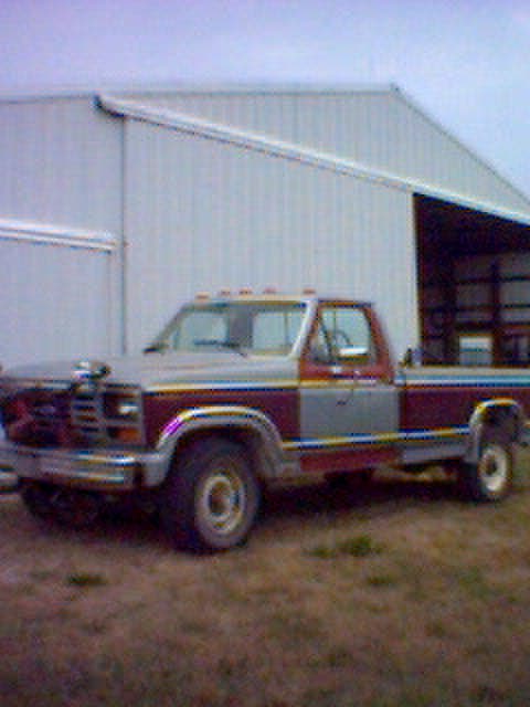 1994 Ford Bronco - This Ford F-Series truck, likely from the early 1980s, is parked outside a large metal structure.