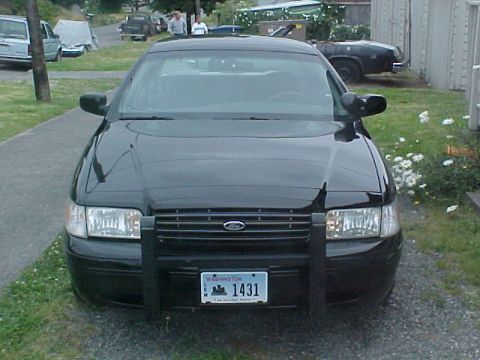 1999 Ford Crown Victoria - Front view of a black Ford Crown Victoria police car, equipped with a push bar and Washington license plate 1431.