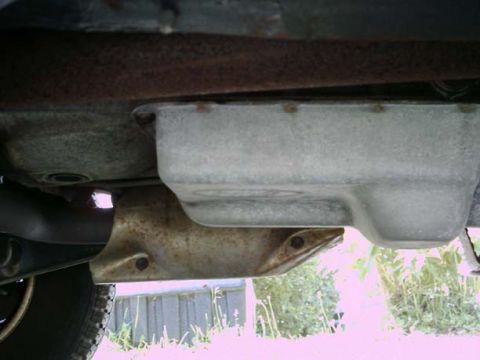1994 Ford Bronco - Underside view of a vehicle's transmission pan and exhaust system, showing drivetrain components.