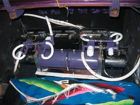 1986 Ford Bronco - Trunk interior shows a custom hydraulic pump system with dual batteries and air tank.