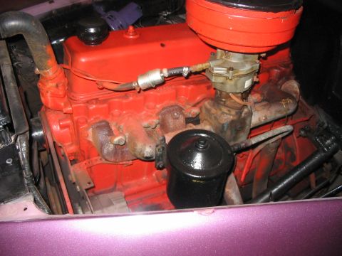 1986 Ford Bronco - The engine compartment shows a red-painted engine block with various hoses and components attached.
