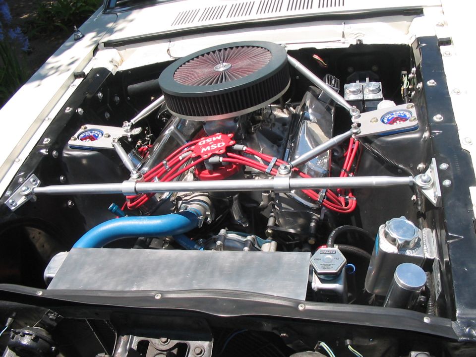 Engine bay showing V8 engine, red MSD ignition wires, chrome valve covers, and large air filter. Blue hose visible