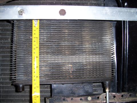 1983 Ford Bronco - A transmission cooler is shown with a tape measure for scale, indicating its dimensions.