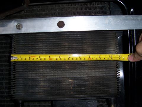1983 Ford Bronco - A close-up view of a radiator being measured with a tape measure.