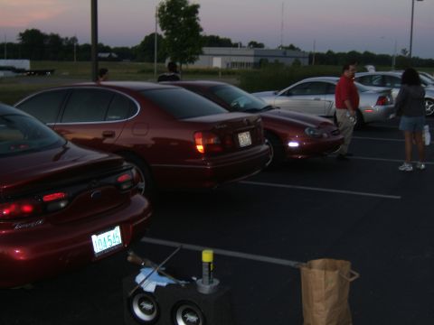 1998 Ford Taurus - A red 1998 Ford Taurus sedan is parked in a lot with other vehicles.