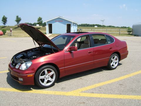 1998 Ford Taurus - A red sedan, likely a Lexus GS from the early 2000s, is parked outdoors with its hood open, revealing the engine compartment.