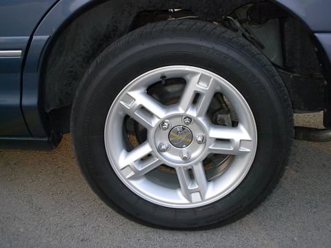 1985 Mercury Grand Marquis - A close-up view of a car's wheel and tire, showing the alloy rim design.