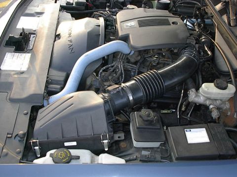 1985 Mercury Grand Marquis - Close-up view of a car's engine bay, showing various components and hoses.